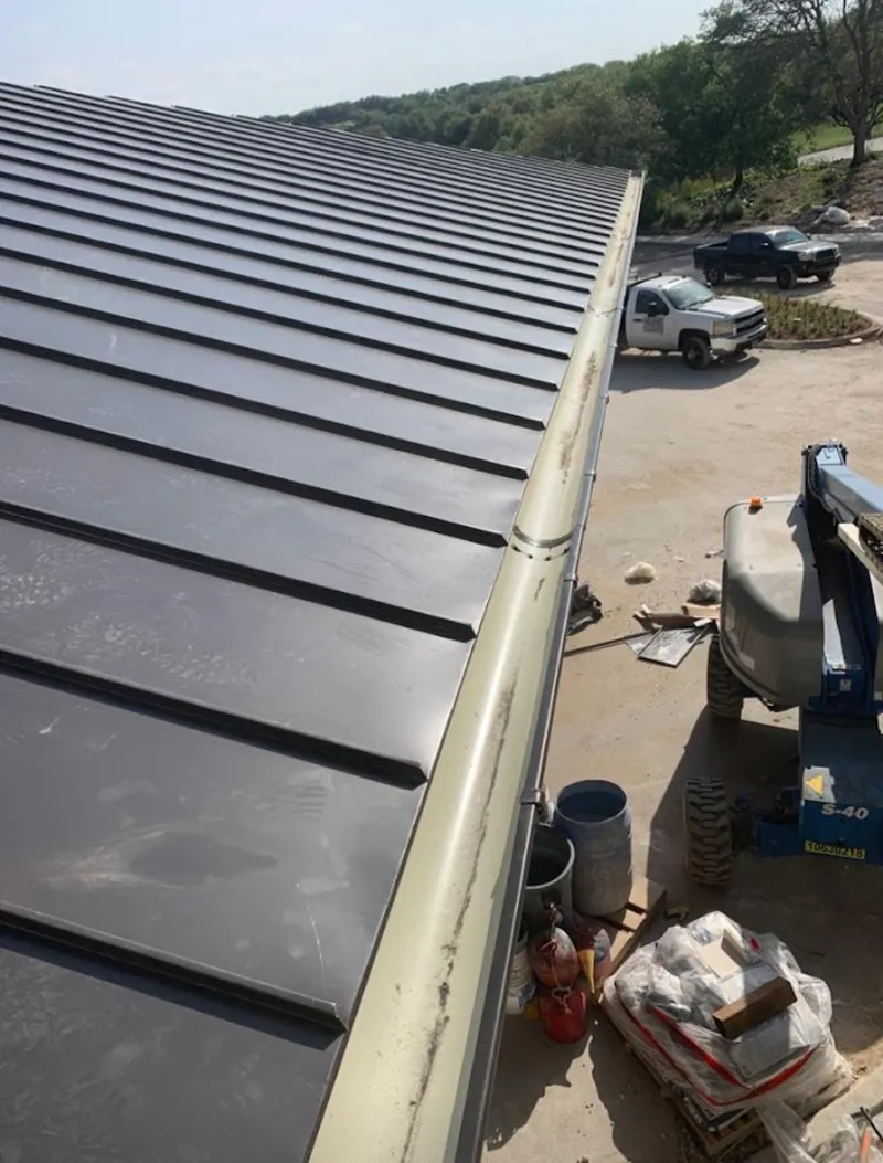 Standing seam panel and gutter detail on a metal roofing jobsite in Ottumwa